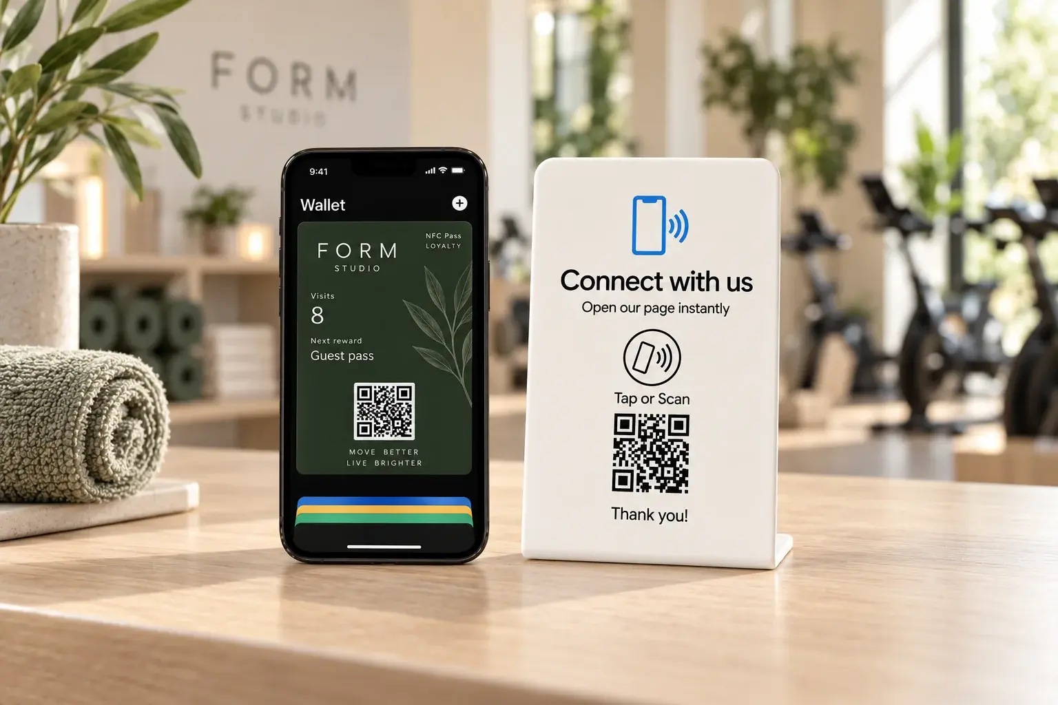 NFCPlate Custom Link Stand beside a FORM Studio NFC Pass visits card at a fitness reception
